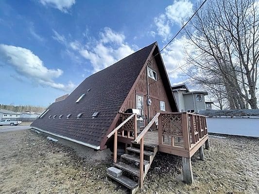 An a-frame house with a deck on the side.