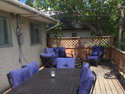 A deck with blue furniture and a table.