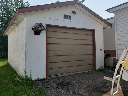 A garage with a boat parked next to it.