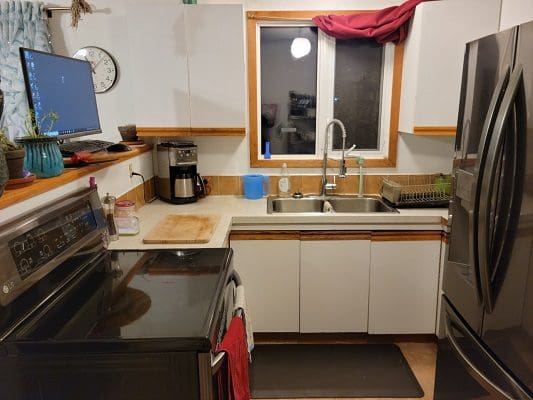 A kitchen with stainless steel appliances and a window.