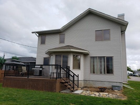 A house with a deck on the side of it.