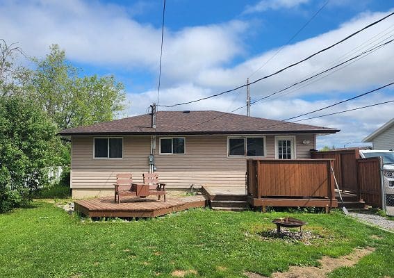 A house with a lawn and a wooden deck.