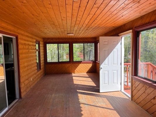 A cabin with a wooden floor and a sliding glass door.