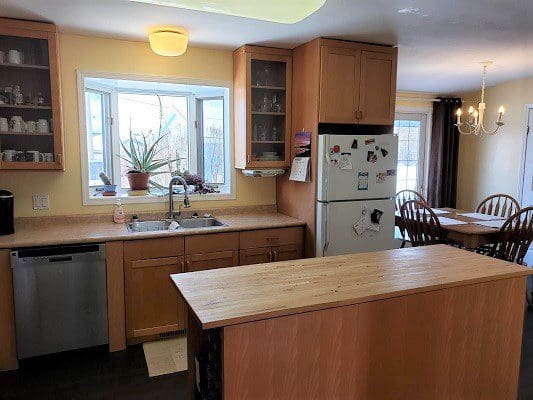A kitchen with wooden cabinets and a wooden counter top.