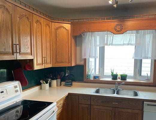 A kitchen with wooden cabinets and a window.