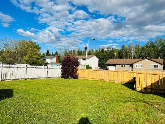 A backyard with a fence and a wooden fence.