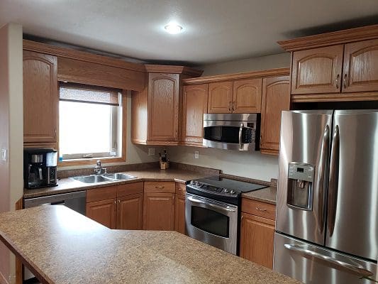 A kitchen with stainless steel appliances and wooden cabinets.