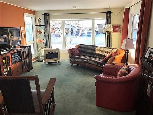 A living room with couches, a television and a fireplace.
