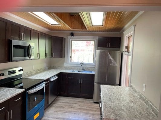 A kitchen with a stove, microwave, and refrigerator.