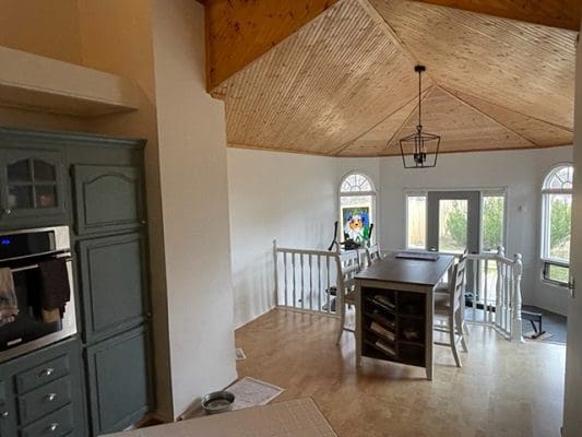 A kitchen with a vaulted ceiling and wood floors.