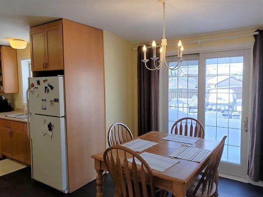 A kitchen with a table and chairs and a refrigerator.