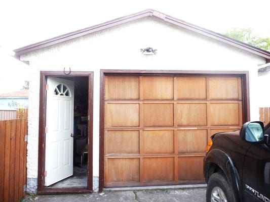 A truck is parked in front of a garage.