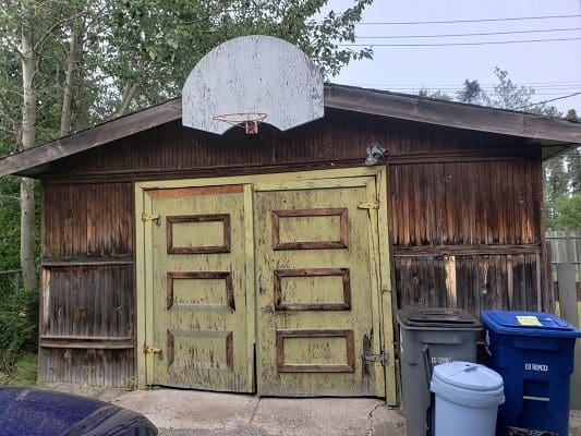 A garage with a basketball hoop and a door.