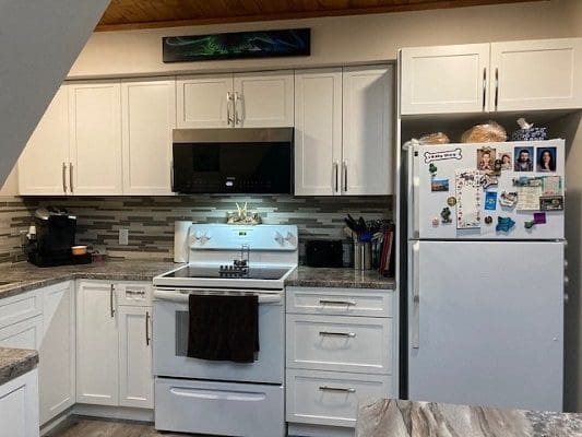 A kitchen with white cabinets and a stove.