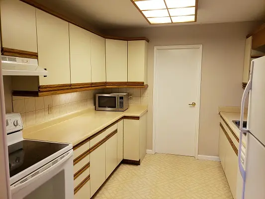 A kitchen with white cabinets and a microwave.