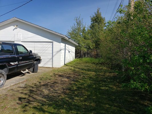 A black truck is parked in front of a garage.