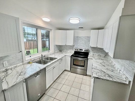 A kitchen with white cabinets and stainless steel appliances.
