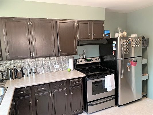 A kitchen with brown cabinets and stainless steel appliances.