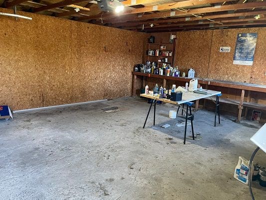 An empty garage with a table and chairs.