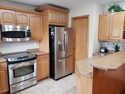 A kitchen with stainless steel appliances and wood cabinets.