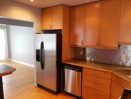 A kitchen with stainless steel appliances and wooden cabinets.
