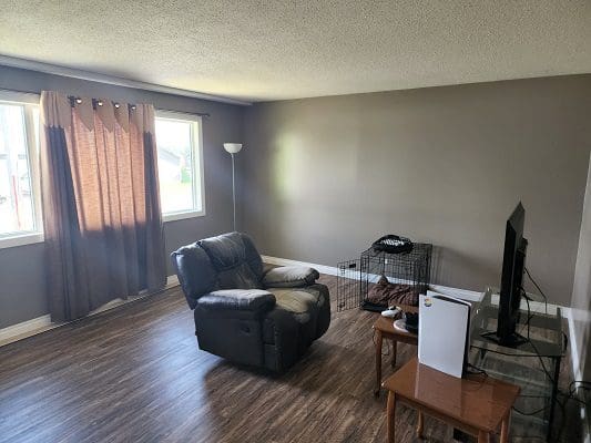 A living room with hardwood floors and a recliner.