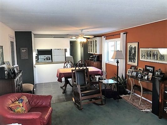 A living room with orange walls and a rocking chair.
