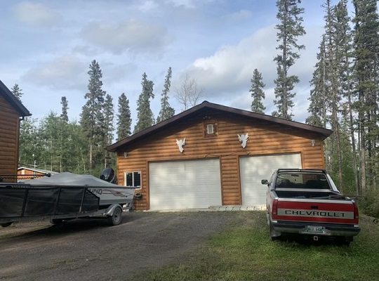 A house with a boat parked in front of it.