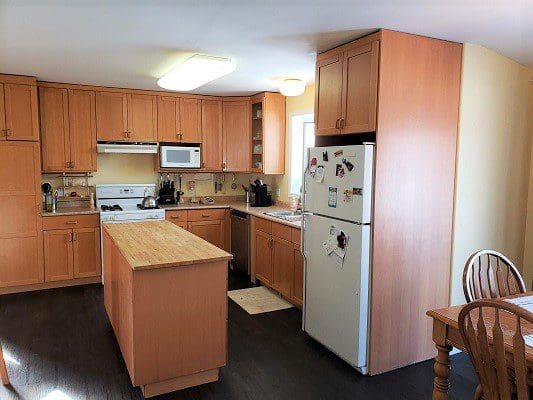 A kitchen with wooden cabinets and a white refrigerator.