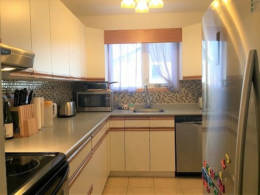 A kitchen with stainless steel appliances and white cabinets.