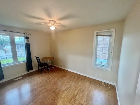 A room with hardwood floors and a ceiling fan.