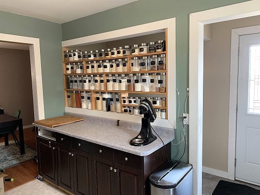 A kitchen with a spice rack and a door.