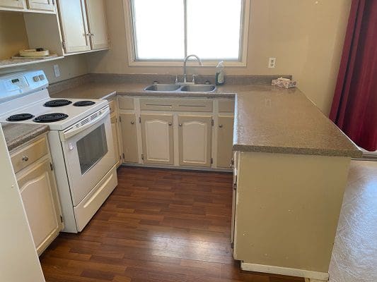 A kitchen with white cabinets and a stove.