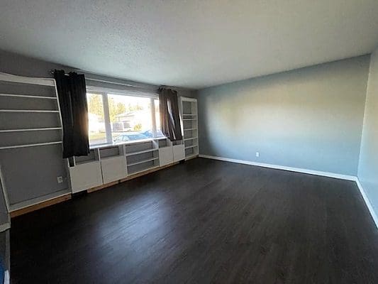 An empty room with hardwood floors and blue walls.