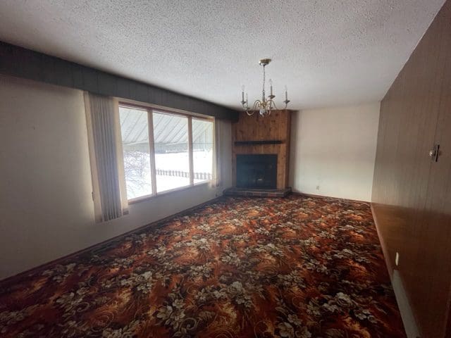 A living room with a fireplace and carpet.
