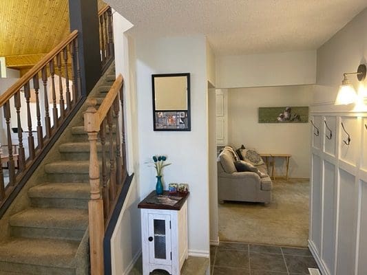 A hallway with a staircase and a stairwell.