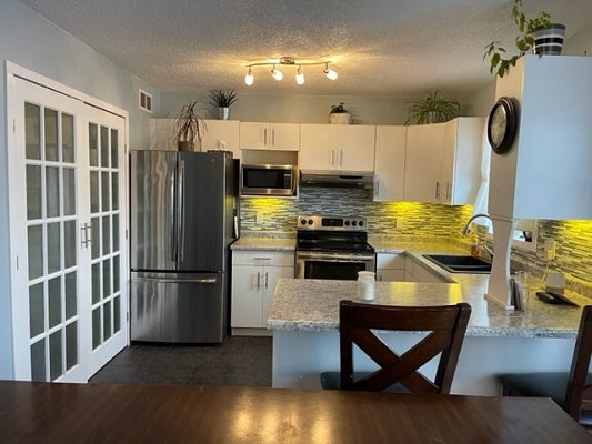 A kitchen with white cabinets and stainless steel appliances.