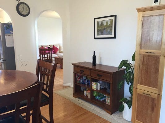 A dining room with a wooden table and chairs.