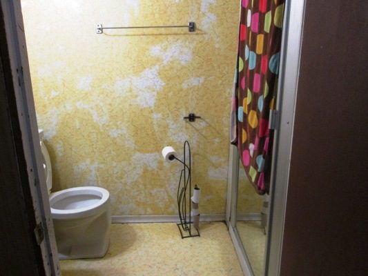 A bathroom with yellow walls and a toilet.