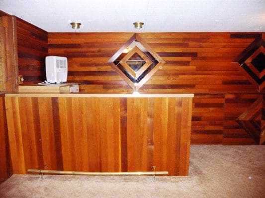 A room with wood paneling and a bar.