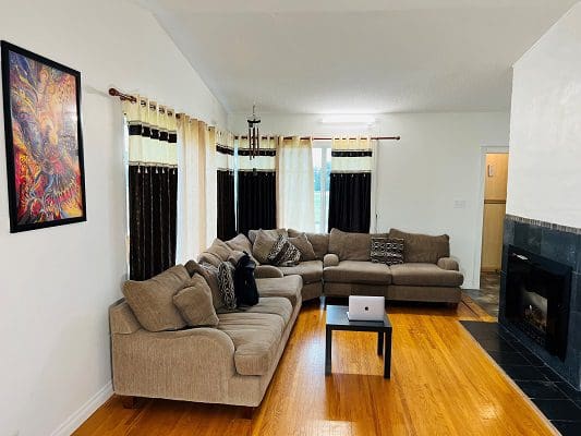 A living room with hardwood floors and a fireplace.