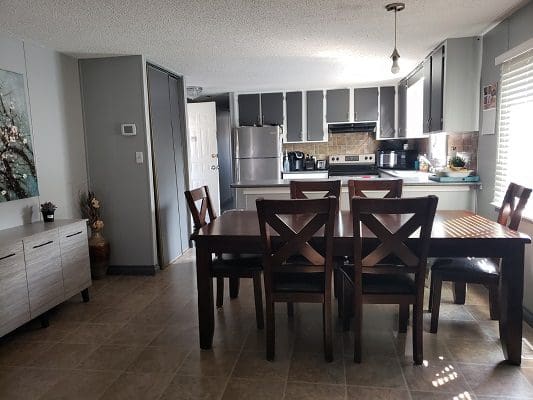 A kitchen with a dining table and chairs.