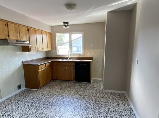 A kitchen with white cabinets and a tile floor.