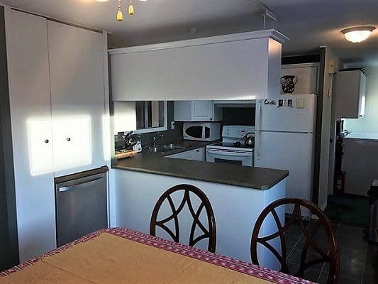 A kitchen with a table and chairs and a refrigerator.