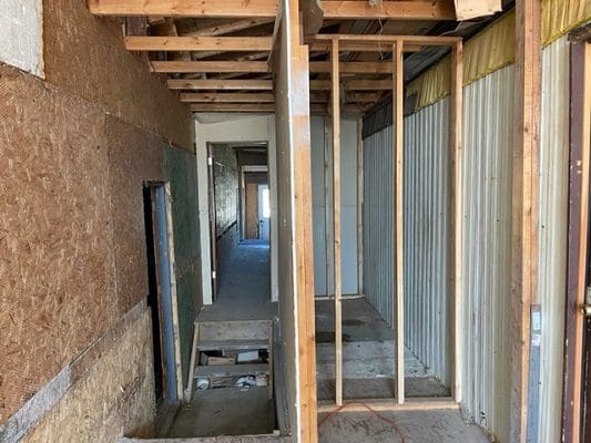 A house is being built with wood framing and a doorway.
