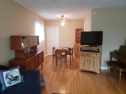 A living room with a tv and a piano.