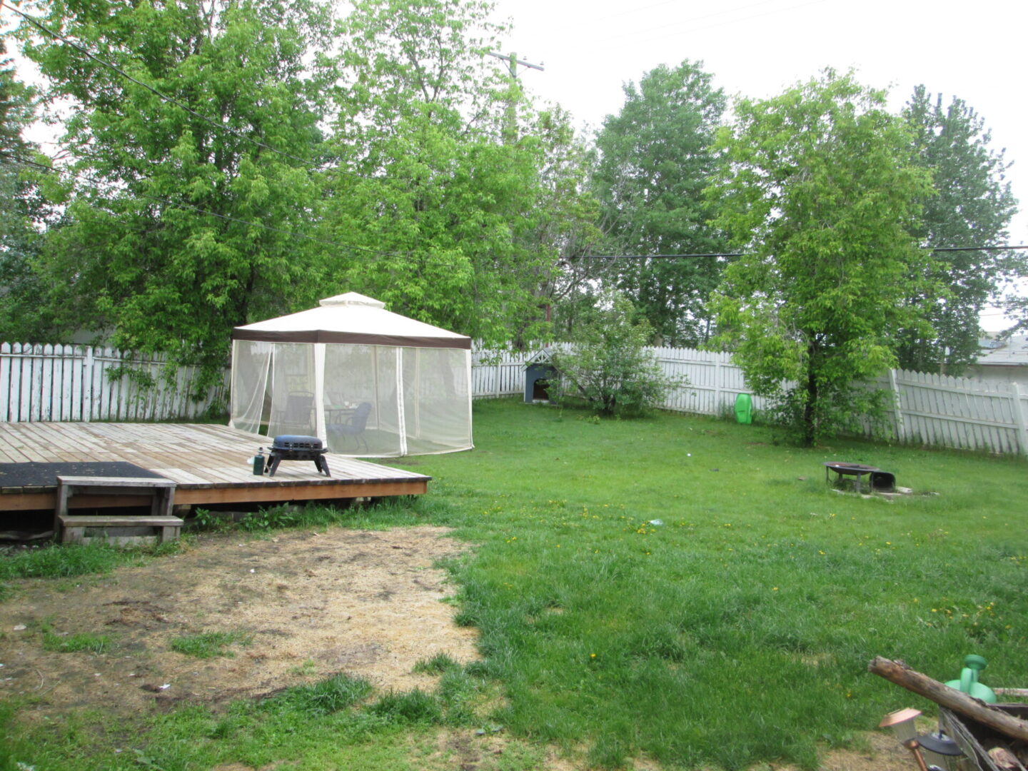 A backyard with a gazebo and a deck.