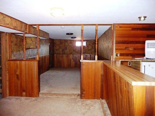A room with wood paneling and a refrigerator.