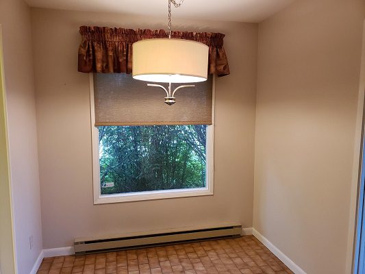 An empty room with a radiator and a window.