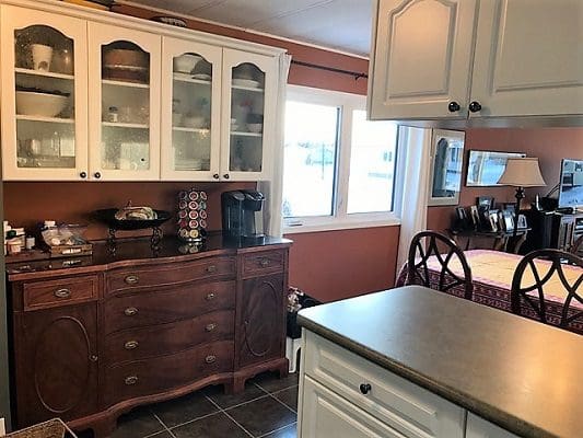 A kitchen with white cabinets and a refrigerator.